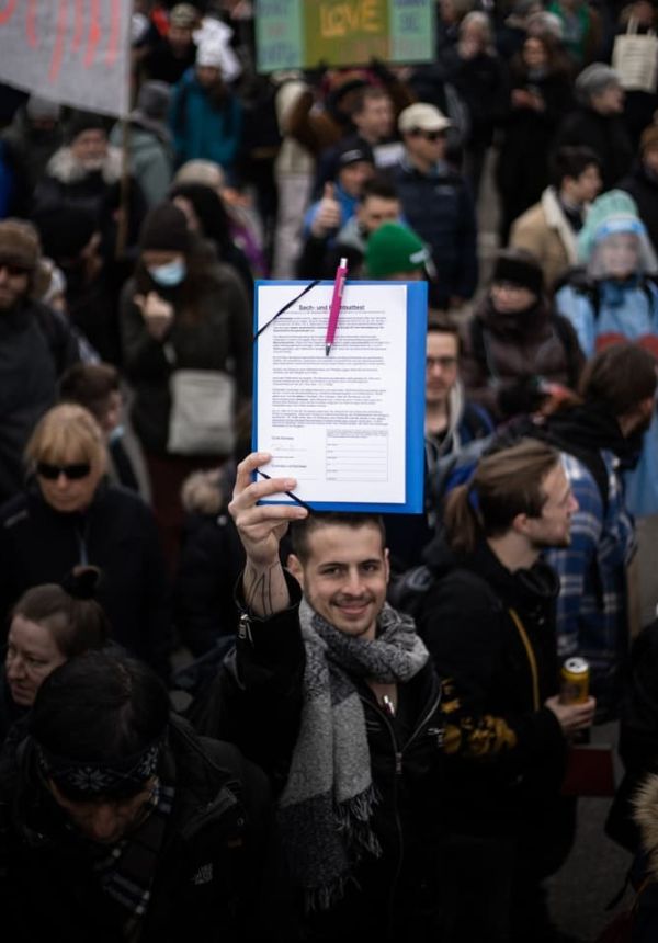  Imagen decorativa Persona con documento en medio de protesta